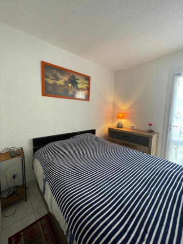 - une chambre avec un lit rayé noir et blanc dans l'établissement Paradis du Soleil-plage de la roquille - 4 personnes- clim-parking, au Cap d'Agde