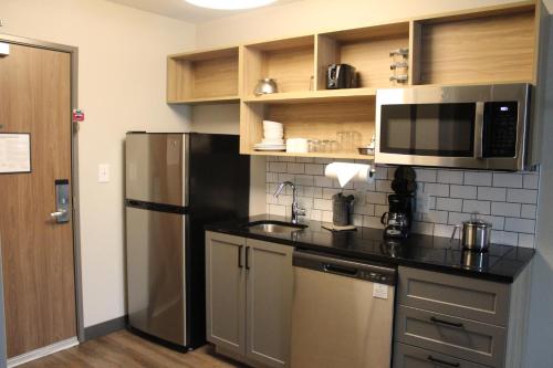 a kitchen with a stainless steel refrigerator and a microwave at Candlewood Suites - Nashville South, an IHG Hotel in Nashville