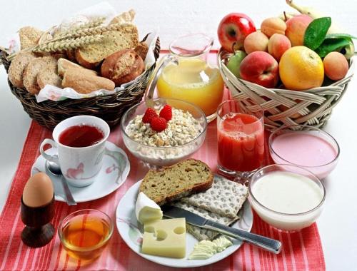 a table with a breakfast of bread and fruit and juice at Hotel Sky Wood At Airport in New Delhi