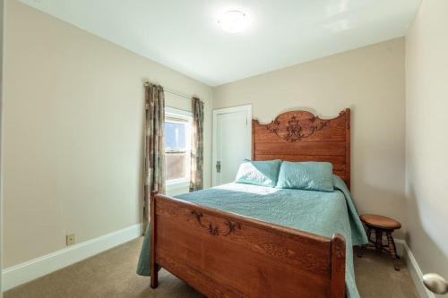 um quarto com uma cama de madeira e uma janela em Comfy Quiet House by Downtown em Coeur d'Alene
