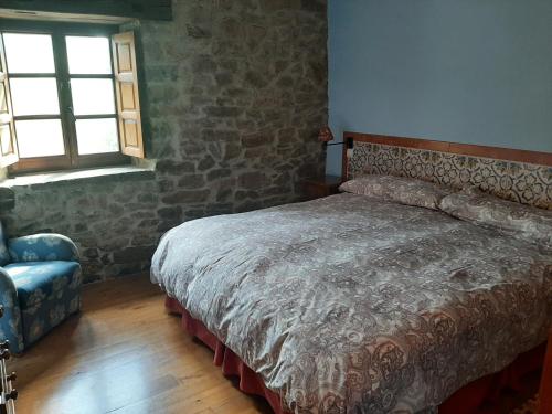 LomeñaにあるApartamento Olmares Picos de Europa - 4 personasのベッドルーム1室(ベッド1台、椅子、窓付)