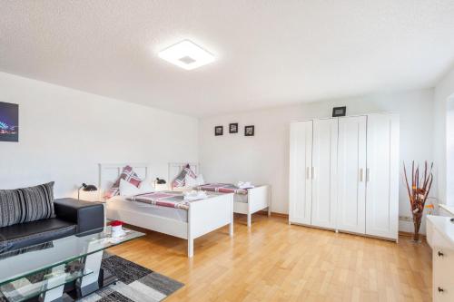 a white room with a bed and a cabinet at Ferienwohnung Am Wald in Herscheid