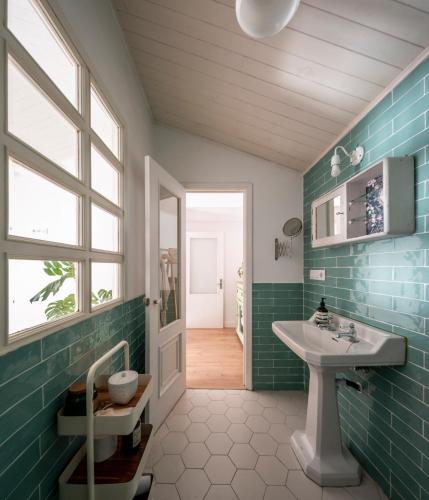 a bathroom with green tiles and a sink at Doni Beach House in A Coruña