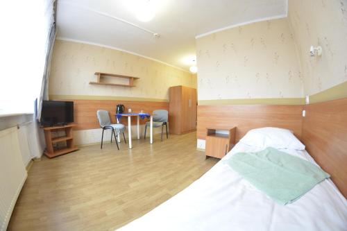 a bedroom with a bed and a table with chairs at Twój Hostel Ruda Śląska in Ruda Śląska