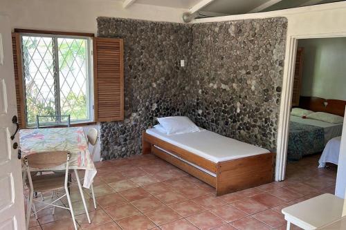 een slaapkamer met een bed, een tafel en een raam bij Villa 8 personas in Puntarenas