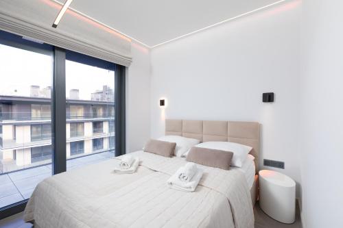 een slaapkamer met een groot bed en een groot raam bij HEVENIA POGORZELICA - Apartament 4 in Pogorzelica