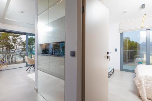 a kitchen with glass doors leading to a living room at HEVENIA POGORZELICA - Apartament 4 z bezpośrednim widokiem na morze in Pogorzelica