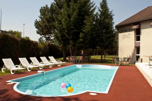 a swimming pool with chairs and balls in the water at Kyriad Nuits-Saint-Georges in Nuits-Saint-Georges