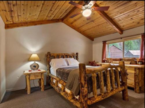 - une chambre avec un lit en bois et un ventilateur de plafond dans l'établissement Cabin 1 at Southfork Lodge- sleeps up to 2, à Lowman
