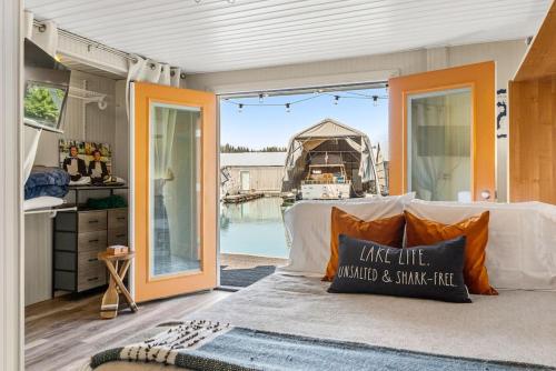 a living room with a bed and a large glass door at Boats N Rows Float Home in Athol