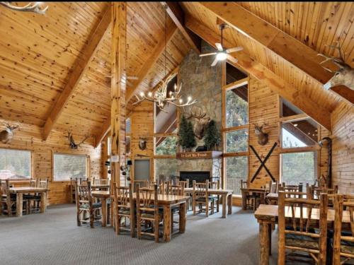 a dining room with wooden tables and chairs and a fireplace at Cabin 3 at Southfork Lodge- Sleeps 2 in Lowman