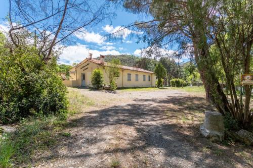 a house in the middle of a yard with trees at Gite 4 entre 2 et 4 personnes in Reynès