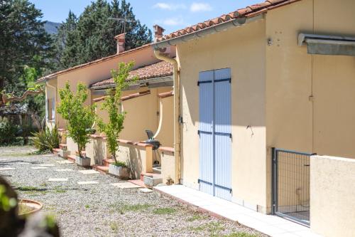 a house with a blue door on the side of it at Gite 4 entre 2 et 4 personnes in Reynès
