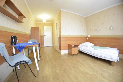 a room with a bed and a desk and a table at Twój Hostel Ruda Śląska in Ruda Śląska