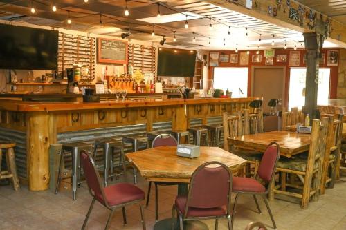 ein Restaurant mit Holztischen und -stühlen und einer Bar in der Unterkunft Queen Suite Ensuite at Southfork Lodge Motel in Lowman