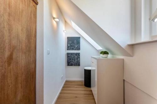 a hallway with a staircase in a house with white walls at Terralpin Apartments - Charmante DG Wohnung mit Balkon in Bruckmühl
