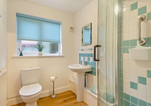 a bathroom with a toilet and a sink and a shower at Mulberry House in Bodham
