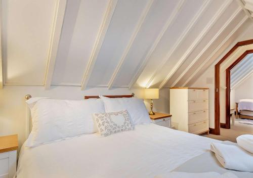 a bedroom with a white bed with a white ceiling at Mulberry House in Bodham
