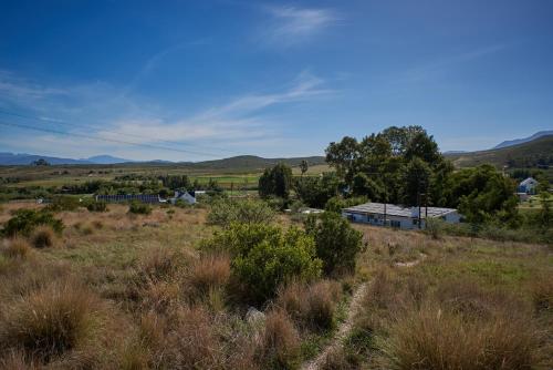 a field of grass with a house in the distance at theLAB Robertson in Robertson