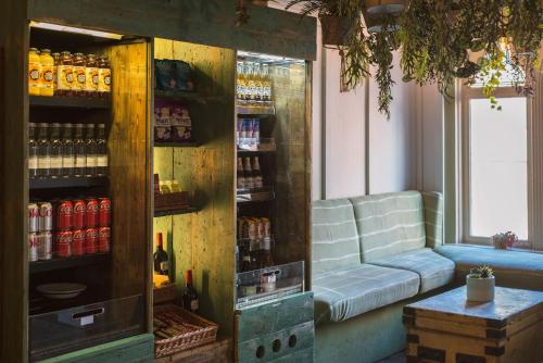 a room with a couch and a shelf with drinks at PH Hostel Liverpool in Liverpool