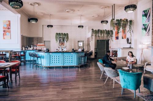 a room with people sitting on a couch and a bar at Malacuna Liverpool in Liverpool