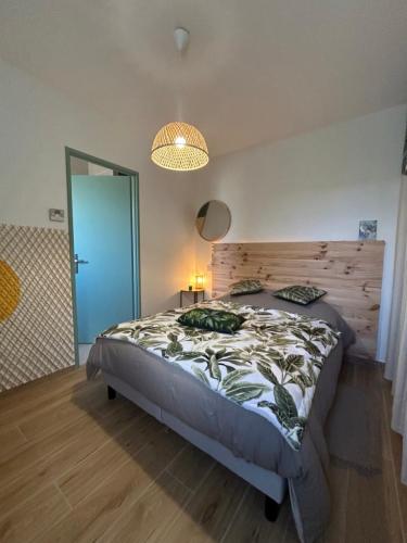 une chambre avec un grand lit avec une tête de lit en bois dans l'établissement L'étoile du Matin avec Piscine Privative, à Margon