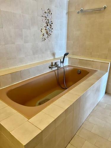 La salle de bains est pourvue d'une grande baignoire avec un robinet. dans l'établissement Charmante maison de village, à Falicon