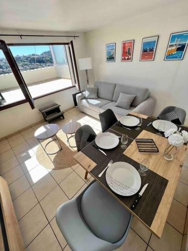 un salon avec une table, des chaises et un canapé dans l'établissement Charmante maison de village, à Falicon