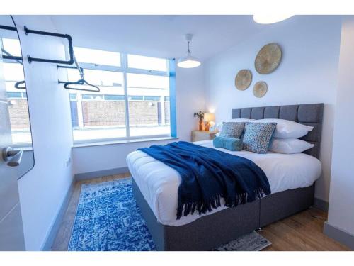 a bedroom with a large bed and a window at Churchside Apartments in Eccles near Trafford and Salford in Manchester