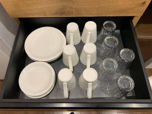 a tray with white plates and glasses on a table at Maizon de Aile Room D in Takasaki