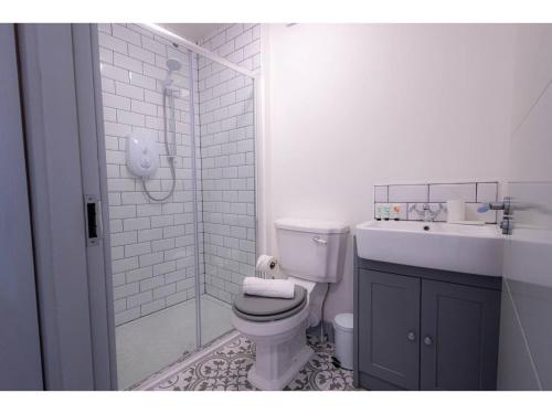 a white bathroom with a toilet and a sink at Churchside Apartments in Eccles near Trafford and Salford in Manchester