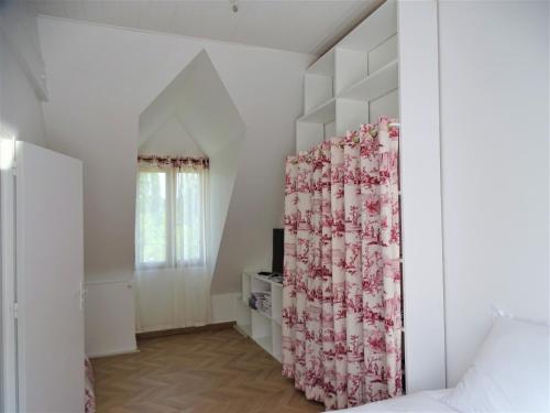 ein Schlafzimmer mit weißen Wänden und einem Bett mit Vorhang in der Unterkunft La Maison de la toile de Jouy in Jouy-en-Josas