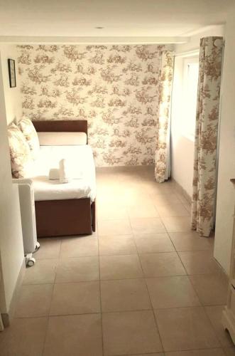 une chambre avec un lit et un sol carrelé dans l'établissement La Maison de la toile de Jouy, à Jouy-en-Josas