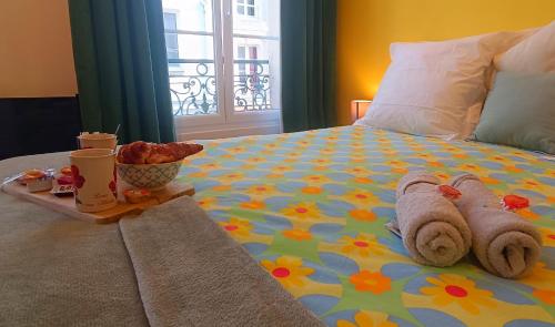 - un lit avec des serviettes et un plateau de nourriture dans l'établissement Appartement de Style - Rue Piétonne - Centre Ville, à Caen