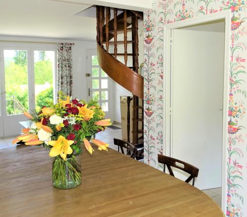 eine Vase voller Blumen auf einem Tisch in der Unterkunft La Maison de la toile de Jouy in Jouy-en-Josas