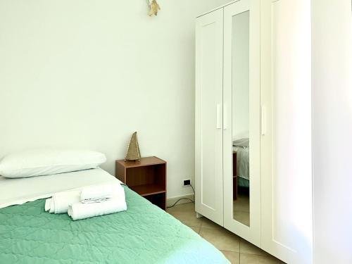 a white bedroom with a bed and a mirror at Appartamento Cutura in Rende