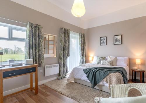 a bedroom with a bed and a desk and a window at Little Oldbury in Hevingham