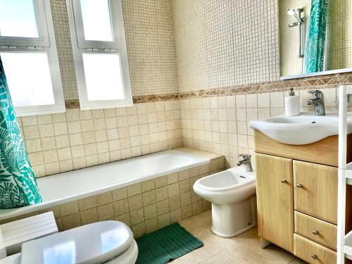 a bathroom with a sink and a toilet and a bath tub at Bright apartment 300m from the beach in Sitio de Calahonda