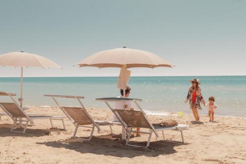 a group of chairs and umbrellas on a beach at Luna Minoica Suites and Apartments in Montallegro