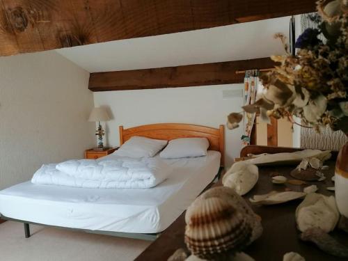 - une chambre avec un lit blanc aux coquillages au sol dans l'établissement La Franqui Appartement cozy deux chambres, à Leucate