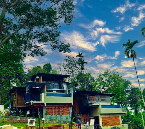 a building with blue trim and a palm tree at MANNATH POOL VILLA in Kozhikode