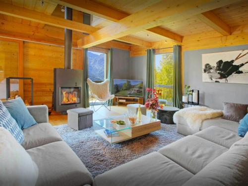 a living room with a couch and a fireplace at Chalet Parakima - OVO Network in Manigod