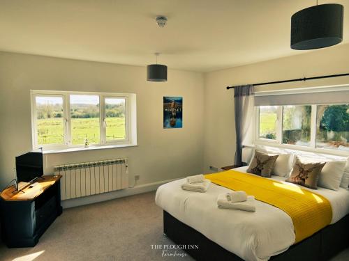 a bedroom with a large bed and a window at The Plough Inn Farmhouse - Private Holiday House in Lenwade