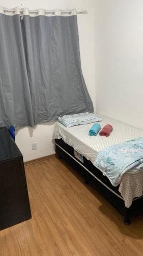 ein kleines Bett in einem Zimmer mit Fenster in der Unterkunft Park marilandia 507 in Juiz de Fora