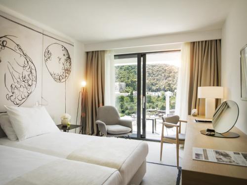 a hotel room with a bed and a balcony at Hotel Kompas in Dubrovnik