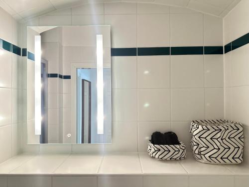 La salle de bains est pourvue d'un miroir et de 2 vases. dans l'établissement Apartment Arenablick, à Leipzig