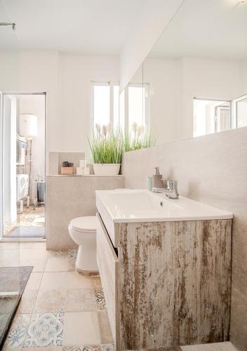 a bathroom with a sink and a toilet at Aroma D Valencia Luxury and Designer Apartment in Valencia
