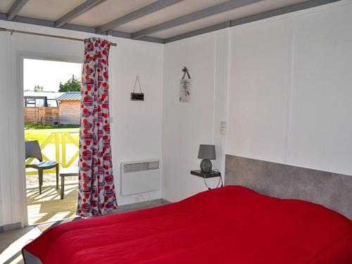 - une chambre avec un lit rouge et un balcon dans l'établissement Les Pommiers de Mont Saint Michel, à Beauvoir