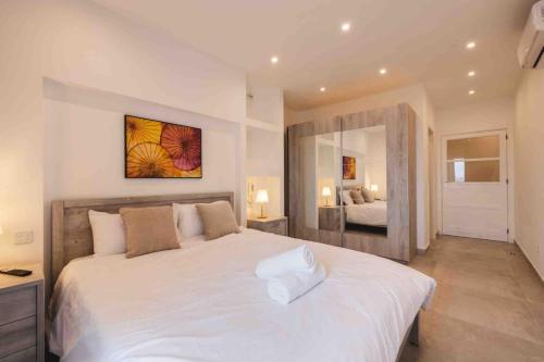a bedroom with a large white bed in a room at Luxurious in Is-Swieqi