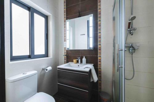 a bathroom with a toilet and a sink and a shower at Blossom Bliss apartment in Msida